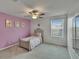 Bedroom featuring a window, ceiling fan, and a closet with mirrored doors at 34780 Rainville Loop, Zephyrhills, FL 33541