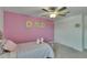 Bright bedroom featuring a pink accent wall, double closet, and cozy plush decor accents at 34780 Rainville Loop, Zephyrhills, FL 33541