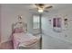 Charming bedroom featuring a ceiling fan, grey carpet, and a wall mirror with ballet-themed decals at 34780 Rainville Loop, Zephyrhills, FL 33541