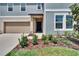 Charming home featuring a welcoming front door with beige siding and an attached garage, with landscaped front yard at 34780 Rainville Loop, Zephyrhills, FL 33541