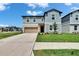 Inviting two-story home with a well-kept lawn, a driveway leading to a two-car garage at 34780 Rainville Loop, Zephyrhills, FL 33541