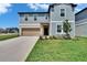 Attractive two-story home featuring a well-maintained lawn and an attached two-car garage at 34780 Rainville Loop, Zephyrhills, FL 33541