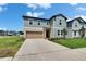 Two-story home with a well-manicured front lawn and convenient two-car garage at 34780 Rainville Loop, Zephyrhills, FL 33541