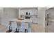 Bright kitchen with white cabinets, stainless steel appliances, and an island with barstool seating at 34780 Rainville Loop, Zephyrhills, FL 33541