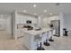 Modern kitchen featuring white cabinetry, stainless steel appliances, and a stylish island with seating at 34780 Rainville Loop, Zephyrhills, FL 33541