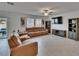 Bright living room features sleek floors, modern furniture, ceiling fan, and backyard access at 34780 Rainville Loop, Zephyrhills, FL 33541