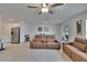 Open-concept living room featuring tile flooring, modern furniture, and access to the kitchen at 34780 Rainville Loop, Zephyrhills, FL 33541