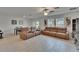 Airy living room showcasing modern furniture, tile flooring, large windows, and neutral paint at 34780 Rainville Loop, Zephyrhills, FL 33541