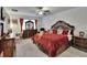 Spacious main bedroom featuring a ceiling fan, carpet floors, and a large bed at 34780 Rainville Loop, Zephyrhills, FL 33541