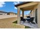 Covered patio with outdoor dining set overlooking the backyard, perfect for relaxing and entertaining guests at 34780 Rainville Loop, Zephyrhills, FL 33541