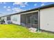 A spacious backyard features a screened-in patio with brick flooring and lush green grass at 3764 Laughing Dove Ave, Sun City Center, FL 33573