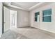 Bright bedroom with two windows, neutral carpet and paint, and a tray ceiling at 3764 Laughing Dove Ave, Sun City Center, FL 33573
