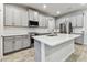 Elegant kitchen with gray cabinets, stainless steel appliances, and a stylish island at 3764 Laughing Dove Ave, Sun City Center, FL 33573