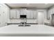 Bright kitchen with stainless steel appliances, gray cabinets, white countertops, and modern faucet at 3764 Laughing Dove Ave, Sun City Center, FL 33573