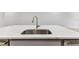Close-up of the kitchen island with a stainless steel sink and modern faucet set against white countertops at 3764 Laughing Dove Ave, Sun City Center, FL 33573
