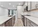 Modern kitchen with stainless steel appliances, white countertops, gray cabinets, and wood-look tile flooring at 3764 Laughing Dove Ave, Sun City Center, FL 33573