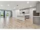 Modern kitchen featuring an island, gray cabinets, stainless steel appliances, and wood-style tile flooring at 3764 Laughing Dove Ave, Sun City Center, FL 33573