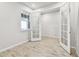 Bright room with wood-look tile flooring, white walls, and natural light from French doors at 3764 Laughing Dove Ave, Sun City Center, FL 33573