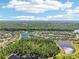 A beautiful aerial view of a residential community with lush greenery, serene lakes, and blue skies dotted with fluffy clouds at 3952 Bonfire Dr, Odessa, FL 33556