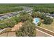 An aerial view of a community, showcasing a pool and playground nestled amongst trees at 3952 Bonfire Dr, Odessa, FL 33556