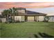 Exterior shot of home and backyard with lush green lawn, landscaping, and solar panels at 3952 Bonfire Dr, Odessa, FL 33556