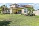 A spacious backyard features lush green grass, a covered patio, and well-maintained landscaping for outdoor enjoyment at 3952 Bonfire Dr, Odessa, FL 33556