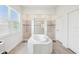 Bright bathroom featuring a large soaking tub and walk-in shower with tiled surround at 3952 Bonfire Dr, Odessa, FL 33556