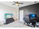 Bedroom with a dark accent wall, ceiling fan, and dual monitors on a black desk setup at 3952 Bonfire Dr, Odessa, FL 33556