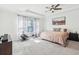 Spacious bedroom featuring ceiling fan, window, carpet, and closet; perfect for relaxation and rest at 3952 Bonfire Dr, Odessa, FL 33556