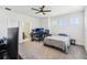 Bright carpeted bedroom with large ceiling fan and a doorway to a bathroom at 3952 Bonfire Dr, Odessa, FL 33556