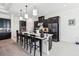Modern kitchen featuring dark cabinetry, stainless steel appliances, and a spacious island with bar seating at 3952 Bonfire Dr, Odessa, FL 33556
