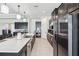 Bright kitchen features stainless appliances, dark cabinets, and a long kitchen island with sink at 3952 Bonfire Dr, Odessa, FL 33556