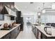 Open kitchen with a long island, stainless steel appliances, and dark cabinets at 3952 Bonfire Dr, Odessa, FL 33556