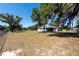 View of the home and large backyard featuring mature trees, green grass and blue skies at 4416 Tevalo Dr, Valrico, FL 33596