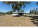 Home exterior featuring a spacious yard, mature trees, and backyard at 4416 Tevalo Dr, Valrico, FL 33596