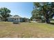 View of the home and large backyard with detached garage, carport and a well-manicured lawn at 4416 Tevalo Dr, Valrico, FL 33596