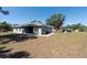 Backyard view of home featuring siding, windows, and a well-manicured lawn at 4416 Tevalo Dr, Valrico, FL 33596