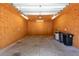 Interior of garage featuring walls with wooden paneling, concrete flooring, and overhead lighting at 4416 Tevalo Dr, Valrico, FL 33596