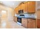 Bright kitchen featuring wood cabinets, black countertops, and tile flooring at 4416 Tevalo Dr, Valrico, FL 33596