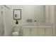 Bright bathroom featuring a double vanity with marble countertop, white cabinets, and tiled shower at 4470 Southern Valley Loop, Brooksville, FL 34601