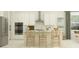 Bright modern kitchen with stainless steel appliances, an island with stools, and white cabinetry at 4470 Southern Valley Loop, Brooksville, FL 34601