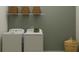 Practical laundry room with modern washer and dryer, wire shelves, and decorative elements at 4470 Southern Valley Loop, Brooksville, FL 34601