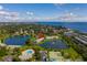 Aerial view of property showcasing lake, pool, tennis court, and water view in a beautiful landscape at 4816 Snook Se Dr # F, St Petersburg, FL 33705