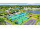 Aerial view of community tennis courts, pool, and lush landscaping at 4816 Snook Se Dr # F, St Petersburg, FL 33705