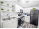 Compact kitchen with black appliances, white cabinets, and a dual stainless steel sink at 4816 Snook Se Dr # F, St Petersburg, FL 33705