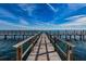 Picturesque view down a long wooden pier extending over serene ocean waters at 4816 Snook Se Dr # F, St Petersburg, FL 33705