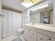 Bright bathroom featuring a white vanity, a large mirror, and a shower with a curtain, offering a clean and functional space at 4900 Brittany S Dr # 211, St Petersburg, FL 33715