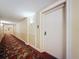 Hallway entrance features a solid white door, plush carpeting, and sconce lighting at 4900 Brittany S Dr # 211, St Petersburg, FL 33715