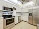 This kitchen includes stainless steel appliances, white cabinetry and modern lighting at 4900 Brittany S Dr # 211, St Petersburg, FL 33715