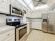 Bright kitchen featuring stainless steel appliances, white cabinetry, and a ceiling fan at 4900 Brittany S Dr # 211, St Petersburg, FL 33715